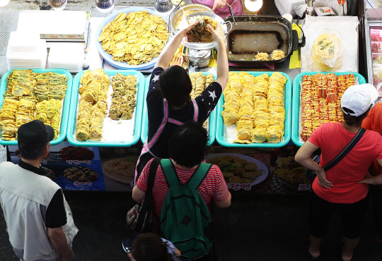 추석 연휴를 앞둔 12일 오후 경기도 수원시 팔달구 못골종합시장에서 시민들이 전을 구입하고 있다.